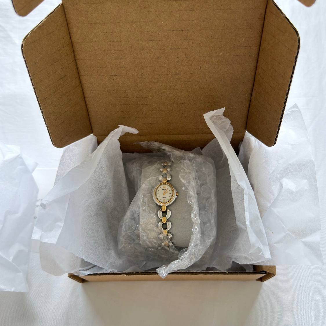 A watch packed in its box, cushioned on a pillow and bubble wrapped